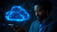 African American businessman in suit looking at glowing blue cloud computing hologram while holding smartphone, representing digital transformation and future technology.