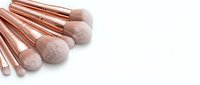 Makeup brushes with rose gold handles and soft bristles arranged on white background for cosmetics and beauty applications.