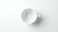 Empty white ceramic cup with handle on white background, overhead view for tableware and kitchenware design projects.