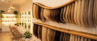Modern surfboard retail store interior with wooden display racks showcasing multiple surfboards in warm lighting creating inviting shopping atmosphere.