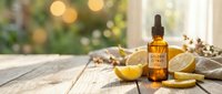 Essential oil bottle with dropper and fresh lemon slices on rustic wooden table with warm bokeh lights creating spa wellness atmosphere.