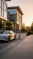 Electric vehicle charging at modern office building during golden hour sunset, sustainable transportation and green energy infrastructure for corporate campuses and urban development projects.