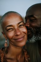 Happy mature African American couple embracing and laughing together outdoors during golden hour sunset showing love and connection in relationship.