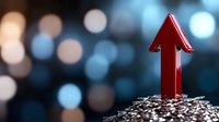 Red upward arrow emerging from pile of silver coins against blurred blue bokeh background, symbolizing financial growth and investment success in business markets.