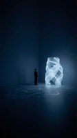 Male figure in dark silhouette standing before glowing abstract geometric sculpture in minimalist interior space. Concept for innovation, creativity, inspiration, vision, and modern design thinking.