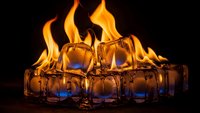Ice cubes melting with dramatic orange flames creating striking contrast between fire and ice elements on dark background for creative concepts.