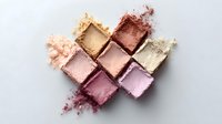 Crushed makeup eyeshadow palette in neutral and pink tones arranged in geometric pattern on light background, showing texture and pigment details for beauty and cosmetics.