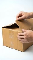 Person with medium skin tone opening empty cardboard box with both hands against white background, suitable for shipping, delivery, unboxing, and logistics concepts.