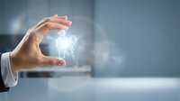 Businessman hand holding glowing light bulb with digital spark effect, representing innovation, creativity, and business ideas for corporate and technology concepts.