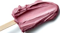 Pink ice cream bar with creamy texture on wooden stick isolated on white background, perfect for food advertising and summer dessert promotions.
