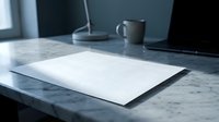Blank white paper sheet on marble desk with laptop and coffee mug in modern office workspace for business presentations and creative projects.
