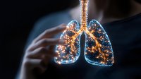 Glowing digital lungs visualization with luminous golden light particles forming respiratory system anatomy on dark background. Medical science concept.