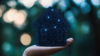 Glowing constellation house silhouette held in palm against blurred bokeh background, symbolizing smart home technology and connectivity.