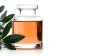 Glass bottle with amber essential oil and fresh green leaves on white background, natural organic aromatherapy product for spa and wellness treatments.