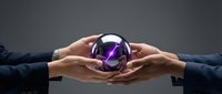 Two businesspeople holding a glowing purple crystal ball together against a gray background, symbolizing shared vision, future prediction, and collaborative strategy for business planning.