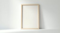 Empty wooden frame mockup on white wall for artwork display and interior design projects.