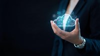 Businessman holding glowing cloud computing technology with digital icons floating above palm representing data storage and connectivity solutions.
