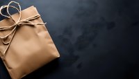 Brown kraft paper wrapped gift box with rustic twine bow on dark background, minimalist holiday or birthday present styling for modern celebrations.