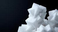 White sugar cubes stacked in pile on dark background. Sweet crystalline granules for cooking, baking and beverage preparation in kitchen and food industry.
