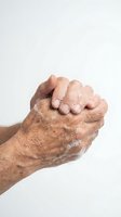Senior man washing hands with soap foam against white background for hygiene and health safety practices.
