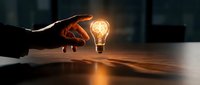 Hand holding glowing light bulb on wooden table in dark office environment, symbolizing innovation, creativity, ideas, and business solutions for corporate projects.