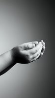 Open cupped hands in black and white photography showing gesture of receiving, giving or protection against gradient background for spiritual concepts.