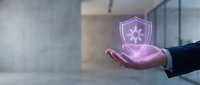 Hand holding glowing purple shield icon with star symbol, representing cybersecurity, data protection, and digital safety solutions for business technology.