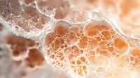 Macro photography of orange and white foam bubbles creating abstract organic pattern with soft bokeh effect and delicate texture for creative backgrounds.