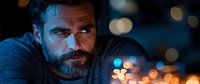 Bearded Caucasian man with intense gaze in dramatic night lighting, bokeh lights in background create moody atmosphere for portraiture and storytelling.