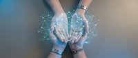 Hands of two people joining together with glowing digital network connections and data visualization overlay, representing teamwork, collaboration, and technology integration.