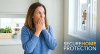 Young Caucasian woman in blue sweater covering mouth in shock looking at broken window glass, home security and property damage concept for insurance.