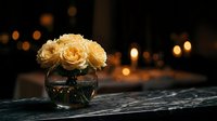 Elegant cream roses in glass vase on wooden table with warm bokeh lights creating romantic atmosphere for home decor and special occasions.