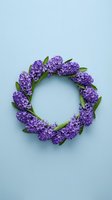 Purple hyacinth flower wreath arranged in circle on light blue background for spring decoration and seasonal design projects.