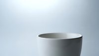 Minimalist white ceramic cup on clean gradient background for modern kitchen and dining concepts.