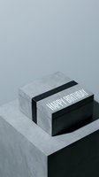 Minimalist happy birthday gift box with black ribbon on concrete podium, monochrome style for modern celebration and luxury packaging concepts.