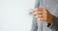 Woman hand holding clear dental aligner orthodontic retainer against white background for teeth straightening treatment and oral care.