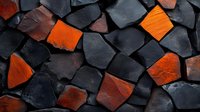 Abstract mosaic pattern of dark gray and vibrant orange stone pieces creating dramatic contrast and geometric shapes on wall surface. Modern architectural detail.