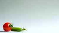 Fresh red tomato and green chili pepper on clean white background for culinary design projects and healthy cooking concepts.