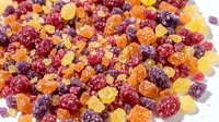 Colorful sugar-coated fruit gels and gummy candies in red, yellow, and orange tones scattered on white background for confectionery and snack designs.