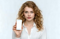 Young blonde Caucasian businesswoman holding smartphone with blank white screen for mockup display isolated on gray background for marketing presentations.