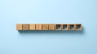 Wooden blocks arranged in a row on light blue background, with some blocks open and empty, representing business concepts, planning, organization, and strategic thinking for corporate projects.