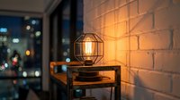 Vintage Edison bulb in geometric cage fixture on wooden table against exposed brick wall with city lights blurred in background, suitable for interior design and home decor projects.