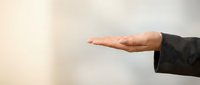 Caucasian male professional extending open palm gesture in business setting, conveying offer, support, or presentation concept for corporate communications.