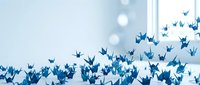 Blue origami paper cranes flying upward in artistic formation against soft bokeh background for creative projects and inspirational designs.