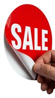 Red sale sticker being peeled back by a hand against white background, revealing white underside. Use for retail promotions and marketing materials.