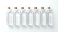 Seven clear glass bottles with cork stoppers arranged in row on white background for packaging design and branding projects.