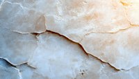 White marble texture with natural cracks and veining in beige and cream tones, showing organic patterns and layered stone surface structure.