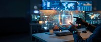 Cybersecurity expert analyzing digital lock hologram on desk with data screens, protecting network infrastructure and preventing cyber attacks in modern office.