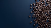 Roasted coffee beans scattered on dark blue background with copy space for café branding, packaging design, or beverage marketing materials.