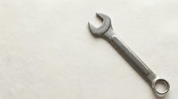 Single chrome wrench tool isolated on white background for mechanical repair work and maintenance projects.